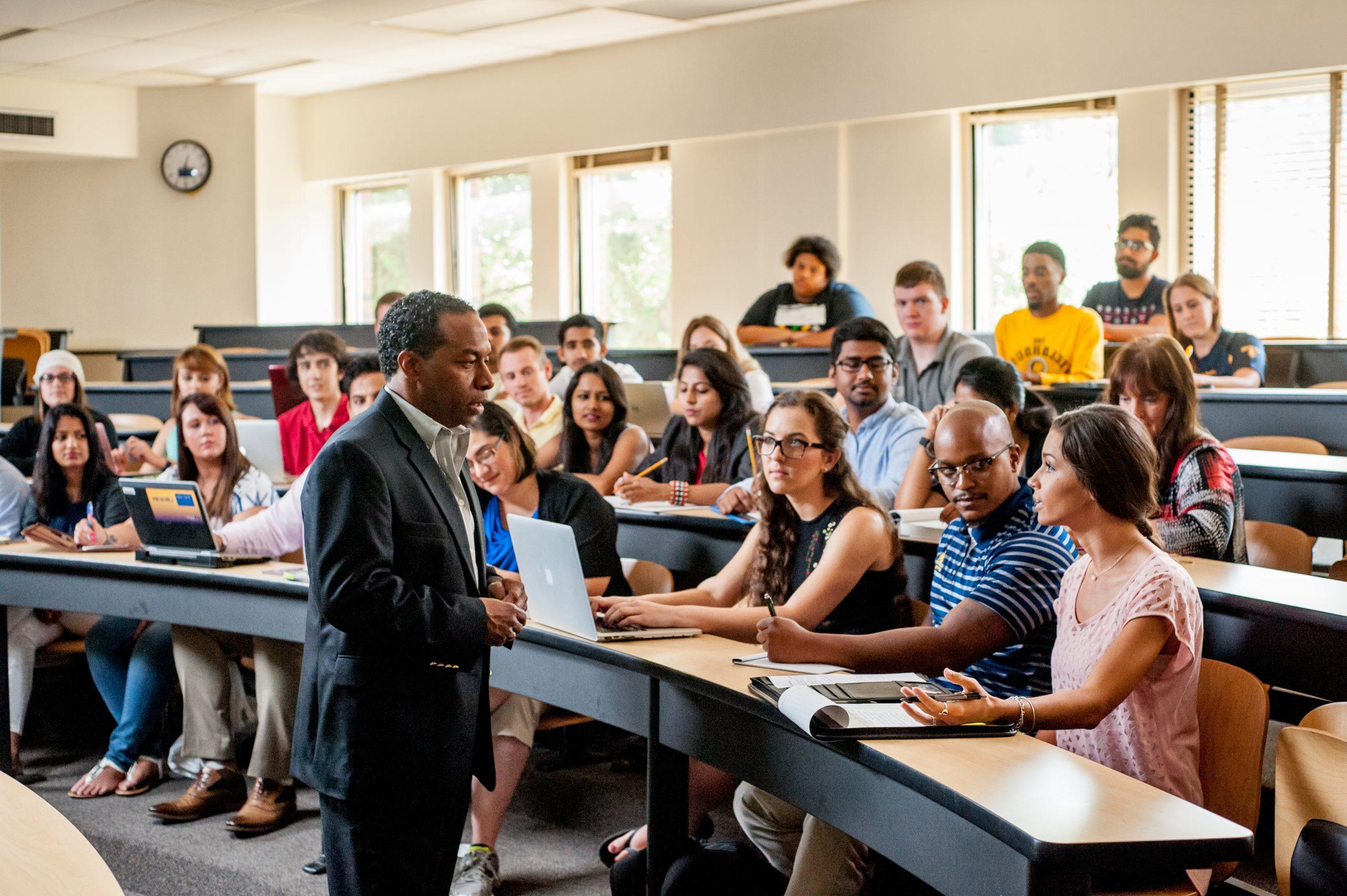 A professor interacts with students during a lecture